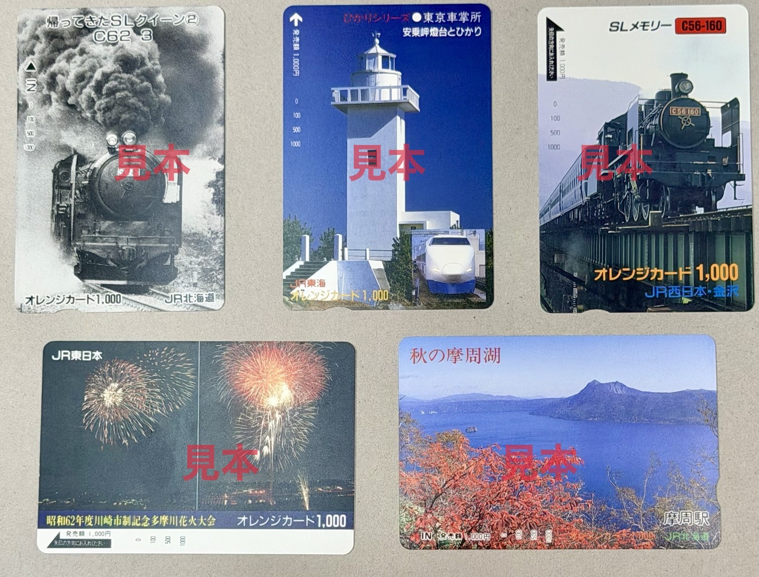 オレンジカード 1,000円券の見本(SL・灯台と新幹線・花火・摩周湖の絵柄)